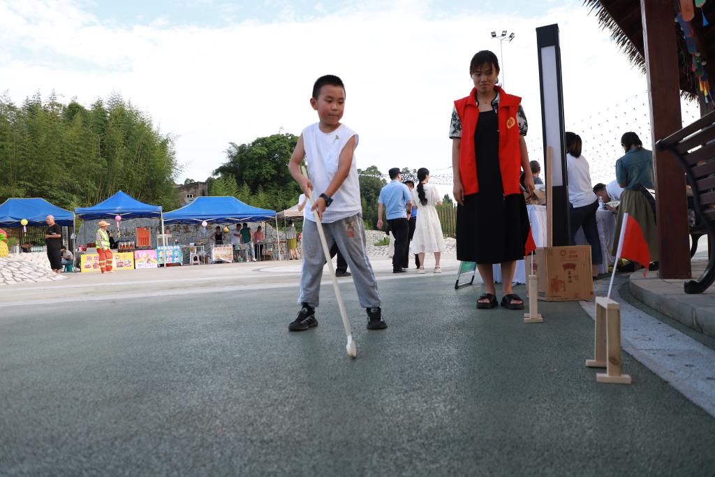 游園會中，小朋友正在體驗傳統游戲曲棍球